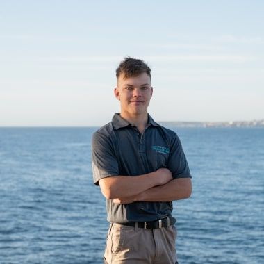 Fynn, dedicated apprentice, with the ocean as his backdrop.