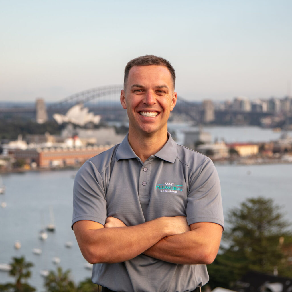 Josh, co-founder, standing outdoors in uniform with the ocean in the background.