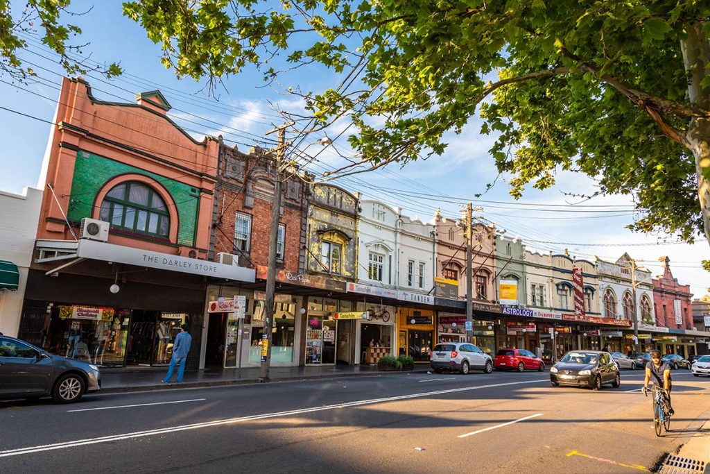 Lively Newtown street lined with historic architecture and leafy footpaths.